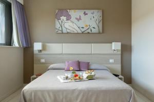a tray of food sitting on top of a bed at Hotel Cristina in Naples
