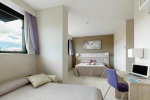 a bedroom with a bed and a desk with a laptop at Hotel Cristina in Naples