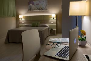 a bedroom with a bed and a laptop on a desk at Hotel Cristina in Naples