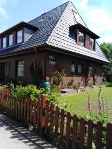 une maison avec une clôture devant elle dans l'établissement Haus Svenja, à Westerland