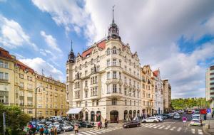 um grande edifício com carros estacionados em frente em Luxurious Kafka family apt in Old Town em Praga