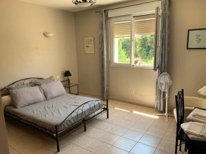 a bedroom with a bed and a window at Chambres Salvaterra in Sauveterre