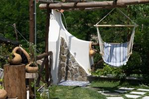 a hammock hanging from a wooden structure in a garden at TRA... INCANTO E NATURA in Tramonti