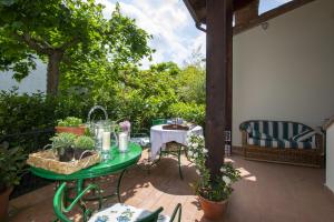 eine Terrasse mit Tisch, Stühlen und Pflanzen in der Unterkunft Villa Mocarello in Poggibonsi