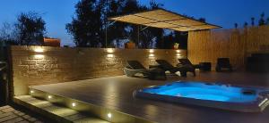 a hot tub on a deck with chairs and a fence at Locanda Mossa Dei Barbari in Buriano