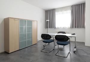 a room with a table and two chairs and a cabinet at Hotel Cristina in Naples