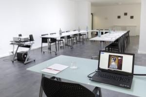 a laptop computer sitting on a table in a classroom at Hotel Cristina in Naples