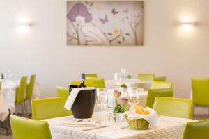 a dining room with a table and green chairs at Hotel Cristina in Naples