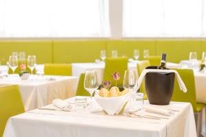 a restaurant with white tables and wine glasses at Hotel Cristina in Naples