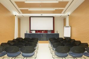 a conference room with chairs and a screen at Hotel Cristina in Naples