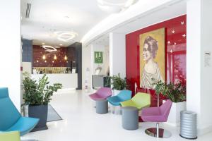 a lobby with colorful chairs and a painting at Hotel Cristina in Naples