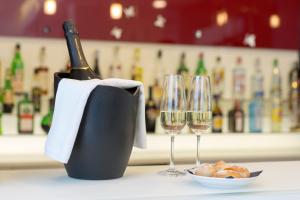 a bottle of champagne and two wine glasses on a counter at Hotel Cristina in Naples