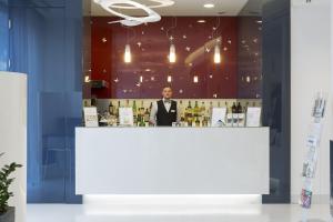 a man standing behind a counter in a bar at Hotel Cristina in Naples