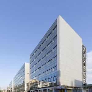 un edificio blanco alto con un cielo azul en el fondo en Hotel Cristina, en Nápoles