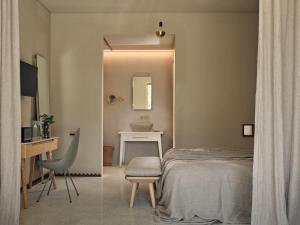 a bedroom with a bed and a sink and a desk at Ekies All Senses Resort, a Member of Design Hotels in Vourvourou