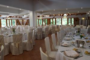 a large banquet hall with white tables and chairs at La Quercia B&B in San Giovanni in Fiore