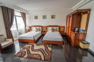a hotel room with two beds and a couch at Duc Long Gia Lai Hotels & Apartment in Pleiku +17 photos