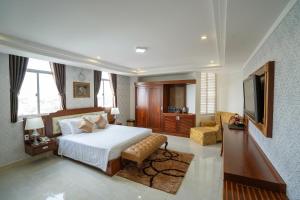 Duc Long Gia Lai Hotels & Apartment في بلاي كو: غرفه فندقيه سرير وتلفزيون