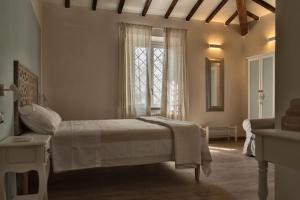 een witte slaapkamer met een bed en een raam bij VISTALAGO VERSILIA in Massarosa