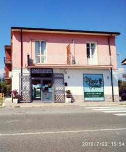 un edificio rosa y blanco en el lateral de una calle en Santa e Maria Affittacamere en Lamezia Terme