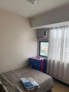 - une petite chambre avec un lit et une fenêtre dans l'établissement Cubao ManhattanHeights Unit 11A Tower B, 2BR, à Manille
