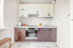 明斯克的住宿－Helen Apartments (Olimp)，厨房配有白色橱柜和烤箱。