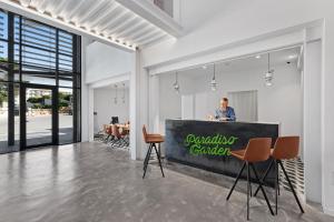 a man standing at a counter in a room with chairs at Hotel Paradiso Garden in Playa de Palma