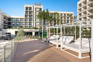 a row of white lounge chairs on a deck in front of a hotel at Hotel Paradiso Garden in Playa de Palma