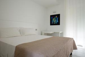 a bedroom with a large white bed with a picture on the wall at Scissure Sea Suite in Gaeta
