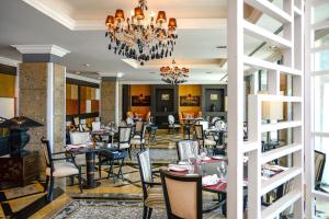 a dining room with tables and chairs and a chandelier at Grande Real Villa Itália Hotel & Spa in Cascais