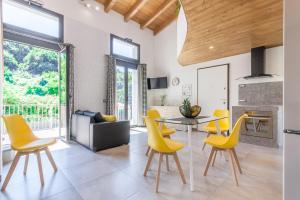 a living room with a table and yellow chairs at Luxury Summer House in La Spezia