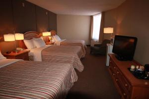 a hotel room with two beds and a television at Confederation Place Hotel in Kingston