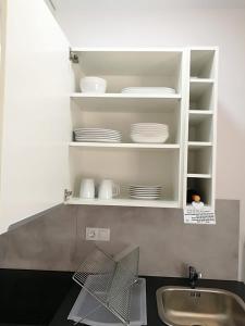 kuchnia ze zlewem i półką z naczyniami w obiekcie Apartamentos Playa Benitez w mieście Ceuta +33 zdjęcia