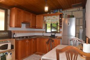 バジェエルモソにあるVilla Carmelaのキッチン(木製キャビネット、ステンレス製の冷蔵庫付)