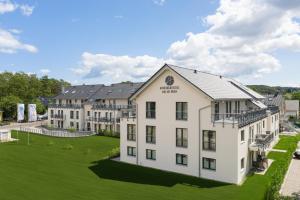 an aerial view of a large white building with a green lawn at AKZENT Apartmenthotel Binz in Binz