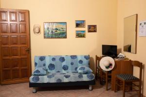 ein Wohnzimmer mit einem blauen Sofa und einem TV in der Unterkunft B&B Panorama in Castelbuono