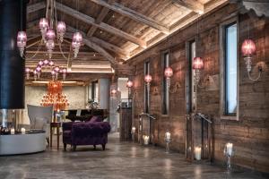 a living room with a purple couch and a chandelier at Cocoon - Alpine Boutique Lodge in Maurach