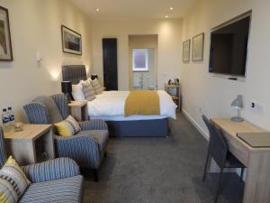 a hotel room with a bed and two chairs at Heatherlea in Kirkwall