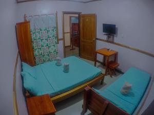 Roxas的住宿－大洋莊園賓館，客房设有两张双层床和电视。