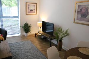 uma sala de estar com uma televisão de ecrã plano sobre uma mesa em City Apartment em Winchester