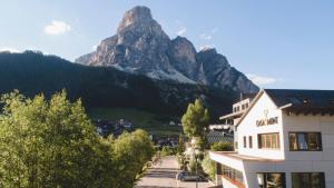 a hotel with a mountain in the background at Ciasa de Munt Lifestyle Living in Corvara in Badia