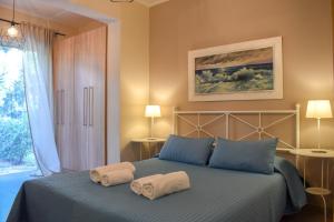 Un dormitorio con una cama azul con toallas. en AVIA HOLIDAY HOME 2, en Avía