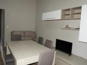 een woonkamer met een tafel, een bank en een televisie bij HOME ORTE in Orte