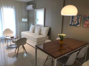 ein Wohnzimmer mit einem weißen Sofa und einem Tisch in der Unterkunft Edificio Celedonio Gutiérrez 651 in San Miguel de Tucumán