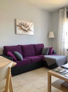 a purple couch in a living room with a table at Lemos Estrella in Monforte de Lemos