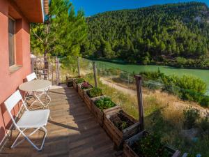 balcón con mesa, sillas y vistas al río en Hostal Avenjúcar, en Tolosa