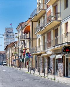 an empty city street with buildings and a tower at La Candelaria in Pisa