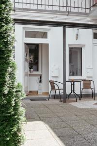 un patio con 2 sillas y una mesa en Apartments Tivoli, en Liubliana