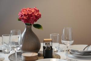 a table with a vase with a red flower in it at Apartments Tivoli in Ljubljana +28 photos
