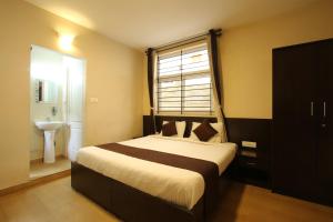 a bedroom with a large bed and a window at The Hill Side in Ooty